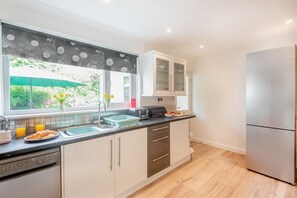Eine moderne Küche mit Geschirrspüler, Spüle und Kühlschrank.