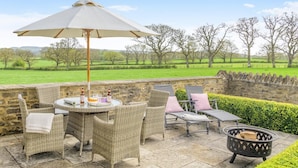 An outdoor patio with wicker furniture, a table with drinks, and a fire pit. - 2 Bed in Sherborne (oc-41897) (Ryme Intrinseca)