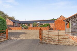 A brick farmstead with a gravel driveway and a metal gate. - 4 Bed in Dorchester (oc-42204) (Sydling Saint Nicholas)