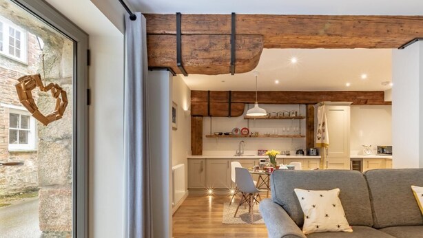 Et moderne interiør med sofa, spisebord og tekøkken.