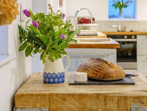 A kitchen counter with a loaf of bread, a jug of milk, and a potted plant. - 4 Bed in Monmouth (oc-42868) (Cwmcarvan)