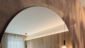 A modern bedroom with a large bed, wooden headboard, and two pendant lights. - ALPEN RELAIS (Fondo)