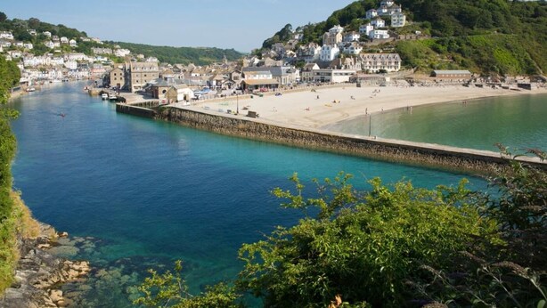 Une ville côtière dotée d’un front de mer dégagé, d’une plage de sable et de bâtiments qui bordent la côte.