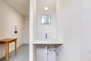 Ein Badezimmer mit Waschbecken, Spiegel und Holztisch.