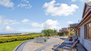 Un patio con mobili da esterno, una cassetta delle lettere e vista sulla campagna.