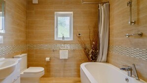 A modern bathroom with a toilet, bathtub, and shower. - 3 Bed in King's Lynn (oc-43259) (Dersingham)