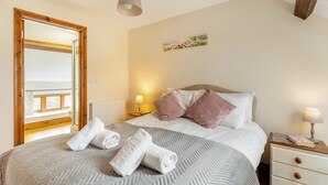 A bedroom with a bed, two bedside tables, a window, a mirror, and a painting on the wall. - 3 Bed in Whitchurch Canonicorum (oc-43398) (Whitchurch Canonicorum)