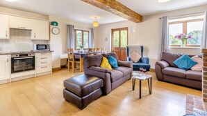 A spacious living area with a kitchen, dining table, and two sofas. - 3 Bed in Whitchurch Canonicorum (oc-43398) (Whitchurch Canonicorum)