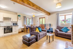 A spacious living area with a kitchen, dining table, and two sofas. - 3 Bed in Whitchurch Canonicorum (oc-43398) (Whitchurch Canonicorum)