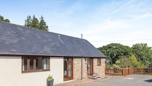 A single-story house with a sloped roof, a front door, and a small porch area. - 3 Bed in Whitchurch Canonicorum (oc-43395) (Whitchurch Canonicorum)