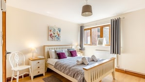 A bedroom with a bed, bedside tables, a chair, a window with curtains, and a painting on the wall. - 3 Bed in Whitchurch Canonicorum (oc-43395) (Whitchurch Canonicorum)