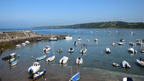 A marina with numerous boats docked, a clear sky, and a hilly landscape in the background. - 2 Bed in Lampeter (oc-43293) (Tregaron)