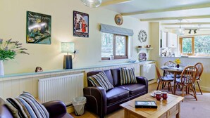 A cozy living room with a sofa, a coffee table, and a dining area with chairs and a table. - 2 Bed in Lampeter (oc-43293) (Tregaron)