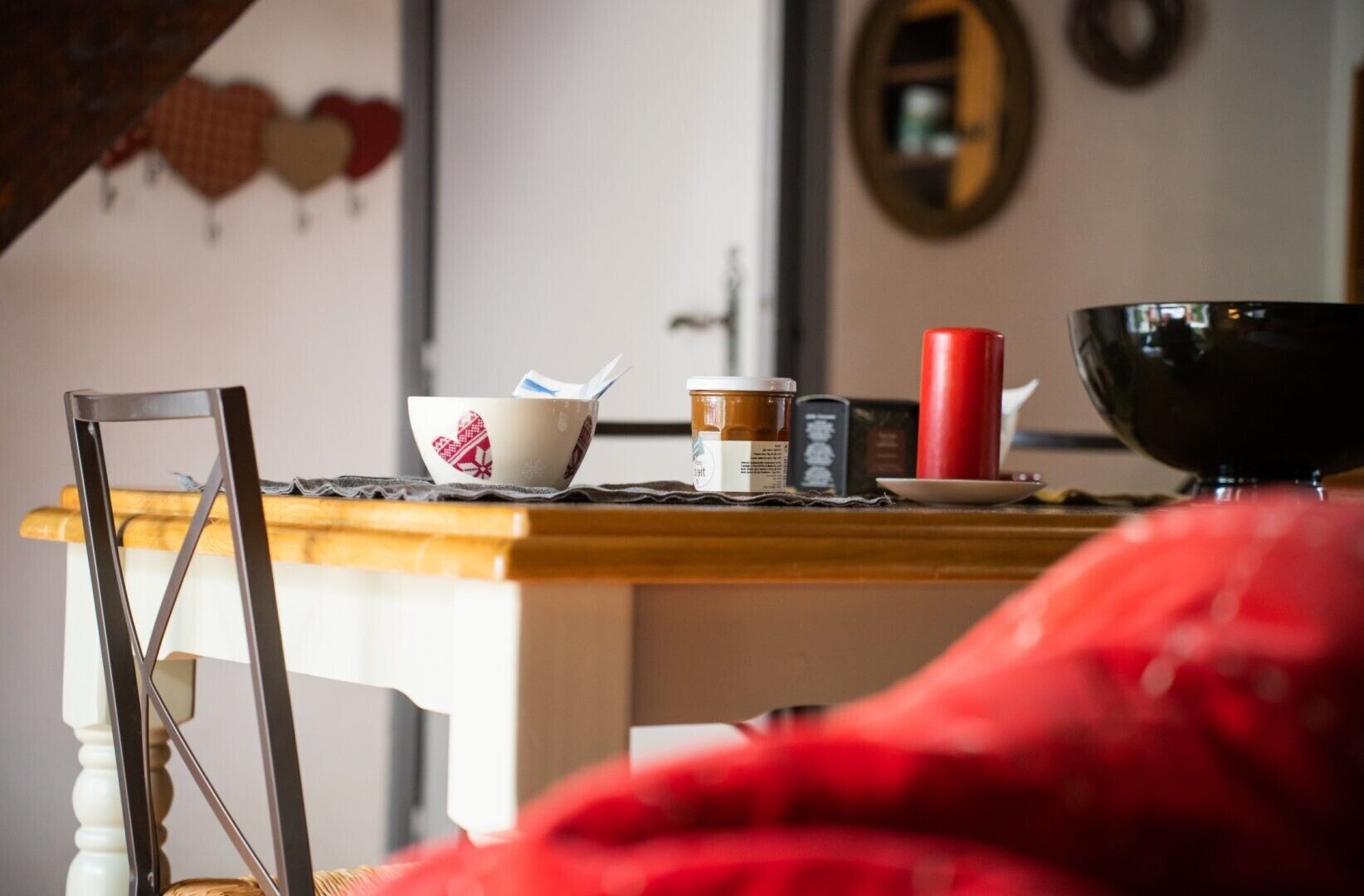 Ein Esstisch mit einer Schüssel, einer Kaffeetasse, einem roten Behälter und einer schwarzen Schüssel.