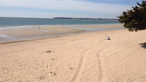 A beach with footprints, a clear sky, and a distant shoreline. - Gîte La Chaumière de Claire - Anouck (Saint-André-des-Eaux)