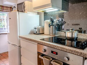 A kitchen with a white refrigerator, a toaster, a stove, and a window with blinds. - 1 Bed in Kidwelly (oc-43409) (Kidwelly)