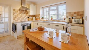 A modern kitchen with a wooden table, a bread loaf, and a toaster. - 2 Bed in Wrexham (oc-43916) (Overton)