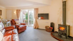 A living room with a sofa, a fireplace, a television, and a dining area with a table and chairs. - 2 Bed in Wrexham (oc-43916) (Overton)