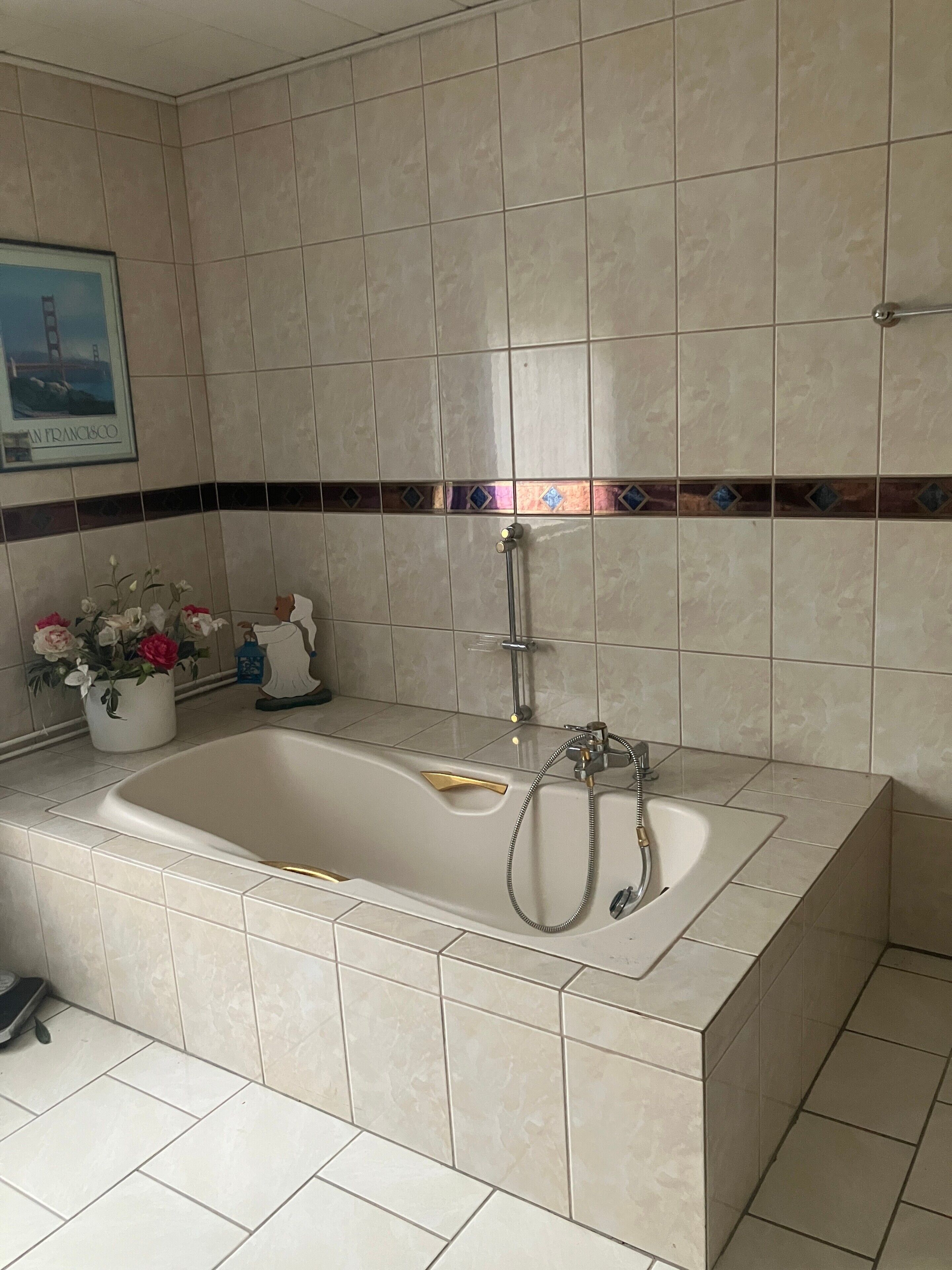 A bathroom with a large bathtub, a shower, and a tiled floor.