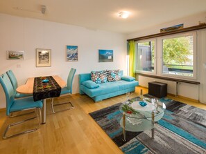 A modern living room with a dining area, a sofa, and a glass coffee table. - Silence / Studio Türkis, (Grächen), 1024 by Interhome (Grächen)