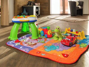A play mat with toys and a small table in a room with wooden flooring and a sofa. - Casa Mia Milleggapark, (Grächen), 1095 by Interhome (Grächen)