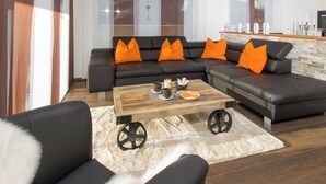 Ein modernes Wohnzimmer mit einem Ecksofa, einem Couchtisch und einem flauschigen Teppich.
