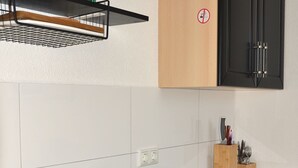 Une cuisine équipée d’un évier à deux bacs, d’un lave-vaisselle et d’un meuble en bois dont la porte est noire.