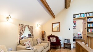 A cozy living room with a sofa, armchair, and a bookshelf. - 4 Bed in High Peak (oc-pk630) (Chapel-en-le-Frith)