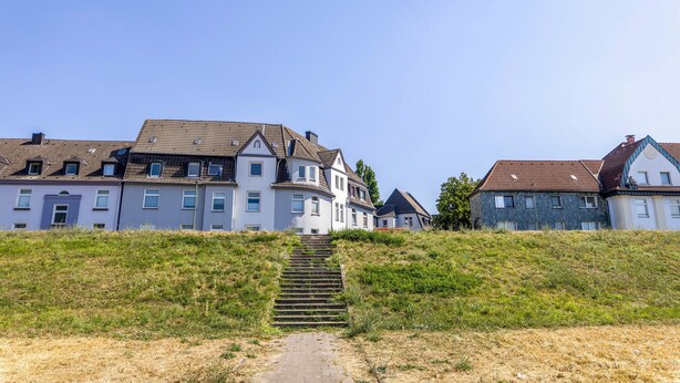 A pathway leading to a row of houses with a clear sky above. - Apartment 'Flora Modern Living' with Wi-Fi (Duisburg)