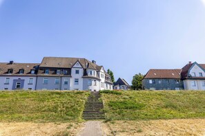 A pathway leading to a row of houses with a clear sky above.