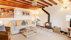 A cozy living room with a sofa, coffee table, and a fireplace. - 2 Bed in Bakewell (oc-44607) (Little Longstone)