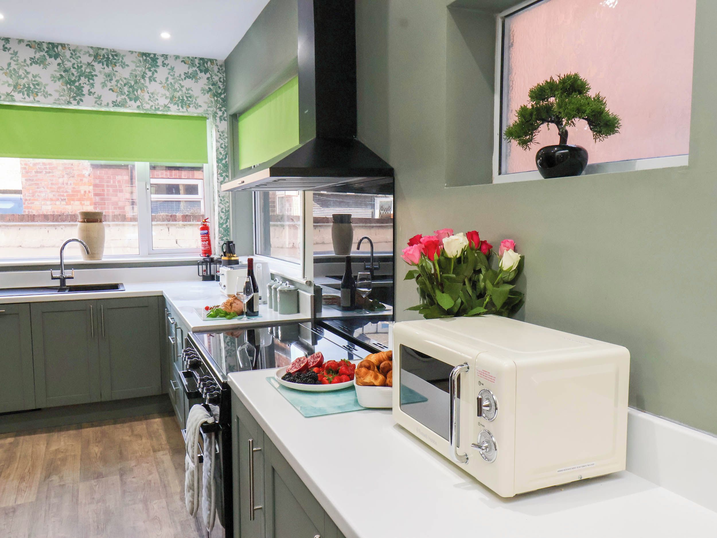 A modern kitchen with a microwave, a sink, and a window with a view of the outside.