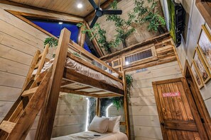 A rustic room with a bunk bed, wooden walls, and a ceiling fan. - Forest Views, Hot Tub, Fireside Nights, Theater room & Family Fun (Sevierville)