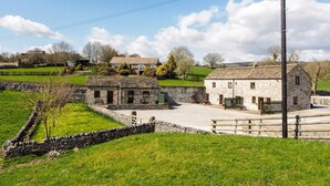 A rural setting with stone buildings, a stone wall, and a grassy field. - 2 Bed in Ashford In The Water (oc-pk502) (Ashford in the Water)
