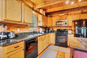 A kitchen with wooden cabinets, a microwave, a refrigerator, a dishwasher, and a coffee maker. - Twin Cub Lodge, 3 Br, 2 Ba, Sleeps 8 & Hot Tub (Townsend)