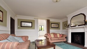 A living room with two striped sofas, a wooden coffee table, a fireplace, and framed pictures on the walls. - 2 Bed in Holmesfield (oc-pk783) (Dronfield)