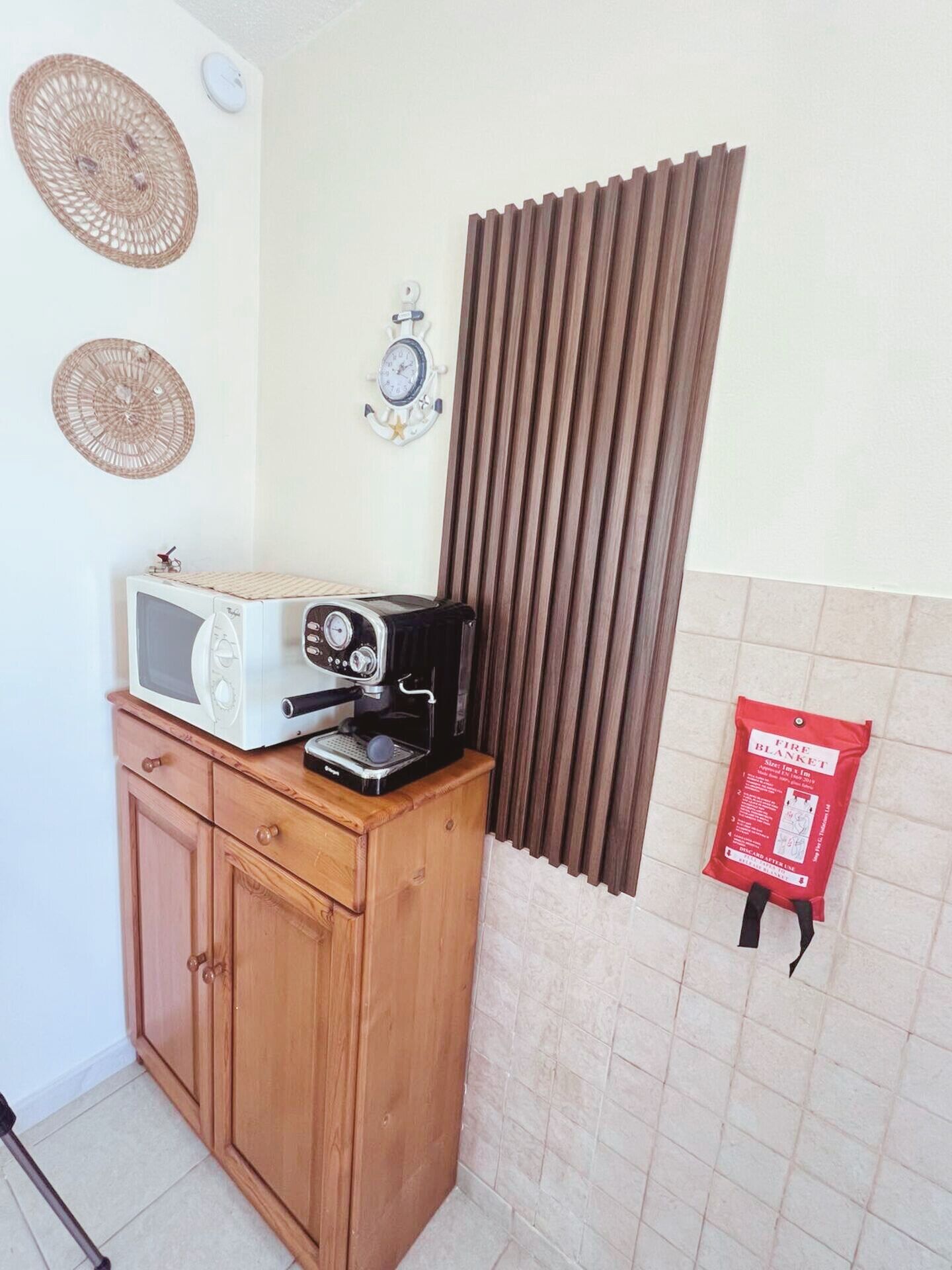 Eine Küchenzeile mit Mikrowelle, Kaffeemaschine und einem Holzkasten.