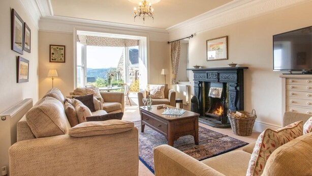 A cozy living room with a fireplace, comfortable seating, and a television. - 4 Bed in Matlock (oc-pk861) (Holloway)