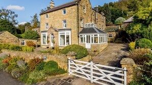 A stone house with a gated entrance, a conservatory, and a well-maintained garden. - 4 Bed in Matlock (oc-pk861) (Holloway)