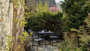 An outdoor patio with stone flooring, a table, and chairs. - 3 Bed in Baslow (oc-pk917) (Baslow)