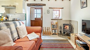 A cozy living room with a sofa, a fireplace, a television, and a bookshelf. - 1 Bed in Wirksworth (oc-pk925) (Wirksworth)