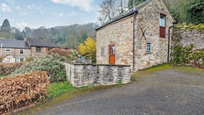 A stone building with a wooden door, a small window, and a chimney. - 1 Bed in Wirksworth (oc-pk925) (Wirksworth)