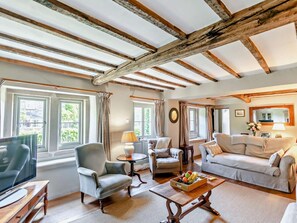 A spacious living room with a high ceiling, large windows, and a cozy fireplace. - 4 Bed in Hope Valley (oc-pk939) (Calver)