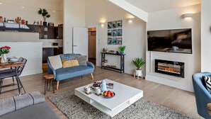 A modern living room with a fireplace, a television, and a dining area with a table and chairs. - 2 Bed in Helston (oc-45739) (Kuggar)