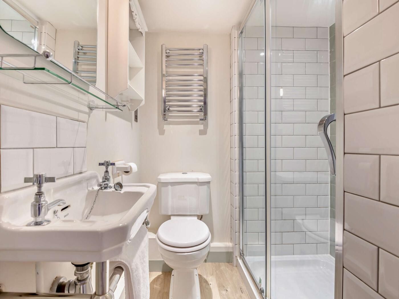 Une salle de bain moderne avec une douche à parois de verre, un lavabo blanc et des toilettes.