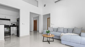 A modern apartment with a kitchen, a living area with a sofa, and a coffee table. - Modern 3BR Villa With Private Pool in Oasis del Lago by Vistacana Rentals (Punta Cana)