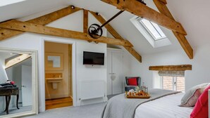 A bedroom with a sloped ceiling, a bed, a TV, and a window. - 4 Bed in Honiton (oc-45563) (Payhembury)