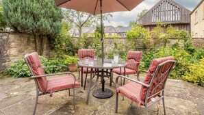 A patio with a round table, four striped chairs, and a large umbrella. - 2 Bed in Bakewell (oc-46032) (Bakewell)