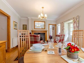A dining room with a wooden table set for four, a fireplace, and a chandelier. - 1 Bed in Cupar (oc-45667) (Ladybank)