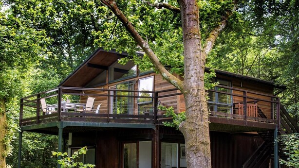 A cabin with a balcony, surrounded by trees. - 2 Bed in Beaulieu (oc-nfl71) (Beaulieu)